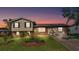 Charming two-story home with a well-manicured lawn and an inviting green front door at dusk at 4908 Celia W Cir, Lakeland, FL 33813