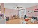 Bright office with pink walls, wood floors, and a ceiling fan at 4908 Celia W Cir, Lakeland, FL 33813
