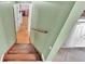 Stairway with wood steps and green walls lead to a pink hallway; laundry is visible next to stairs at 4908 Celia W Cir, Lakeland, FL 33813