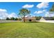 Expansive backyard with lush green grass, a mature shade tree, and a white privacy fence at 5370 Knights Station Rd, Lakeland, FL 33810