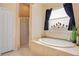 Bright bathroom featuring a soaking tub, separate shower, and beige tile at 5370 Knights Station Rd, Lakeland, FL 33810