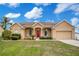 Charming single Gathering home with a well-manicured lawn and inviting front porch with a red door at 5370 Knights Station Rd, Lakeland, FL 33810