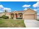 Charming single Gathering home with a well-manicured lawn and inviting front porch with a bright red door at 5370 Knights Station Rd, Lakeland, FL 33810