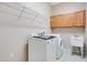 Functional laundry room with cabinetry, utility sink, and modern washer and dryer at 5370 Knights Station Rd, Lakeland, FL 33810