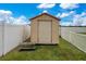 Well-maintained shed with access steps enclosed by a white privacy fence at 5370 Knights Station Rd, Lakeland, FL 33810