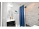 Bathroom with a shower with blue shower curtain, modern sink, and a large mirror at 544 Avenue G Se, Winter Haven, FL 33880