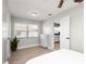 Bright bedroom features wood-look flooring, window, ceiling fan, and white dresser with view to the kitchen at 544 Avenue G Se, Winter Haven, FL 33880