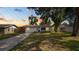 Inviting single-story home with a manicured front lawn, set against a beautiful sunset sky at 544 Avenue G Se, Winter Haven, FL 33880