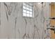 Modern bathroom featuring stylish white marble tile, window and sleek shower fixtures at 5722 Antler Trl, Lakeland, FL 33811