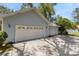 A three-car garage exterior with light blue siding and white garage doors at 5722 Antler Trl, Lakeland, FL 33811
