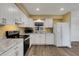 Open kitchen with white cabinets, stone countertops and flooring that flows into the adjacent rooms at 5722 Antler Trl, Lakeland, FL 33811