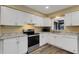 Bright kitchen featuring white cabinets, stainless steel appliances, and stone countertops at 5722 Antler Trl, Lakeland, FL 33811