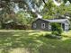 Backyard view of renovated home with gray paint, white trim, privacy fence, and well-maintained yard at 6127 Crews Lake Rd, Lakeland, FL 33812