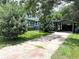 Exterior view of updated home with gray paint, white trim, and driveway leading to carport at 6127 Crews Lake Rd, Lakeland, FL 33812