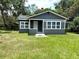 Close exterior view of renovated home with gray paint, white trim, and manicured front lawn at 6127 Crews Lake Rd, Lakeland, FL 33812