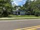 Street view of updated home with appealing gray paint, white trim, and mature trees creating private setting at 6127 Crews Lake Rd, Lakeland, FL 33812