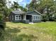 Charming exterior view of updated home with gray paint and white trim in a lush green yard at 6127 Crews Lake Rd, Lakeland, FL 33812