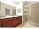 Bathroom featuring double sink vanity with granite countertop and walk-in shower with glass doors at 6524 Great Bear Drive Blvd, Lakeland, FL 33805