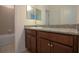 Bathroom showing wood vanity with granite counter, sink, large mirror and tile tub and shower at 6524 Great Bear Drive Blvd, Lakeland, FL 33805