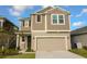 Two-story home featuring a two-car garage, neutral siding, and a well-maintained front lawn at 6524 Great Bear Drive Blvd, Lakeland, FL 33805