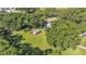 Aerial view of a home with a green lawn, storage shed, and mature trees at 6533 Angus Dr, Lakeland, FL 33810