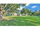 Large backyard with green grass, mature trees, a shed, and the home at 6533 Angus Dr, Lakeland, FL 33810