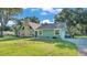 Charming single-story home with stone chimney, green siding, and mature trees at 6533 Angus Dr, Lakeland, FL 33810