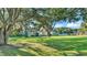 Single-story home with large yard shaded by mature trees at 6533 Angus Dr, Lakeland, FL 33810