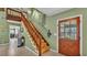Inviting foyer with wooden staircase and views into dining area at 6533 Angus Dr, Lakeland, FL 33810