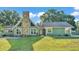 Inviting one-story home featuring a stone chimney and well-manicured lawn at 6533 Angus Dr, Lakeland, FL 33810