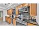 Modern kitchen with stainless steel appliances, granite countertops, and wood cabinets at 6533 Angus Dr, Lakeland, FL 33810