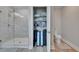 Bathroom with a glass-enclosed shower, shelving with linens, and luggage storage at 7116 Cruz Ct, Lakeland, FL 33813