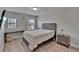 Well-lit bedroom with two windows, wood-look flooring, and modern furniture at 7116 Cruz Ct, Lakeland, FL 33813