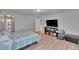 Well-lit bedroom featuring wood-look floors, a bed, and television console at 7116 Cruz Ct, Lakeland, FL 33813