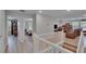 Bright hallway leading to a living area and bedrooms, complemented by white railings and wood-look floors at 7116 Cruz Ct, Lakeland, FL 33813