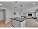 Bright kitchen featuring an island with seating, stainless appliances, modern lighting, and an open view to the living area at 7116 Cruz Ct, Lakeland, FL 33813