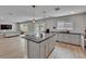 Open layout kitchen showcasing stainless steel appliances, a granite island, modern pendant lights, and wood-look flooring at 7116 Cruz Ct, Lakeland, FL 33813