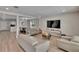 Bright living room features stylish furniture, a wall-mounted TV, and light wood-look flooring at 7116 Cruz Ct, Lakeland, FL 33813