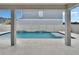 A stunning backyard pool with a built-in waterfall feature, framed by covered patio columns at 7116 Cruz Ct, Lakeland, FL 33813