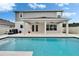 Backyard pool and patio with french doors leading inside and white gravel surrounding at 7116 Cruz Ct, Lakeland, FL 33813