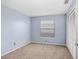 Carpeted bedroom with built-in closet, a window and base molding at 8818 Tottenham Way, Kissimmee, FL 34747