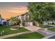 Charming two-story home featuring a well-manicured lawn, mature tree, and a gray stucco exterior at 8818 Tottenham Way, Kissimmee, FL 34747