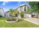 Charming two-story home with well-manicured lawn, mature tree, and an attached two-car garage at 8818 Tottenham Way, Kissimmee, FL 34747