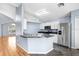 Modern kitchen with stainless steel appliances, ample counter space and herringbone floors at 8818 Tottenham Way, Kissimmee, FL 34747