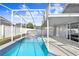 Backyard swimming pool and attached spa featuring screened enclosure and white fence at 8818 Tottenham Way, Kissimmee, FL 34747