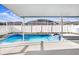 Backyard swimming pool and attached spa with a white screened enclosure and deck at 8818 Tottenham Way, Kissimmee, FL 34747