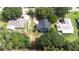 An aerial perspective of a house nestled amidst a landscape filled with trees at 910 Van Dr, Auburndale, FL 33823