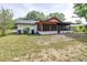Exterior view of the back of the home with a screened in porch at 910 Van Dr, Auburndale, FL 33823