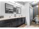 Bathroom featuring double sinks, black cabinets, and framed mirrors at 910 Van Dr, Auburndale, FL 33823