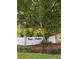 Community entrance sign surrounded by mature trees and landscaping at 910 Van Dr, Auburndale, FL 33823